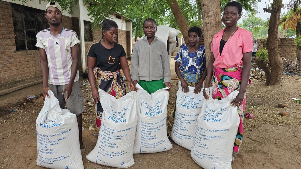 Malawians hold GMO grain bags during a food distribution exercise in Chikwawa district. Photo: Oris Chimenya/USAID