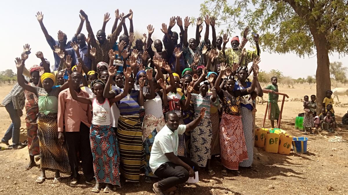 Group of Villagers and Water User Association Raising Hands Looking at Camera