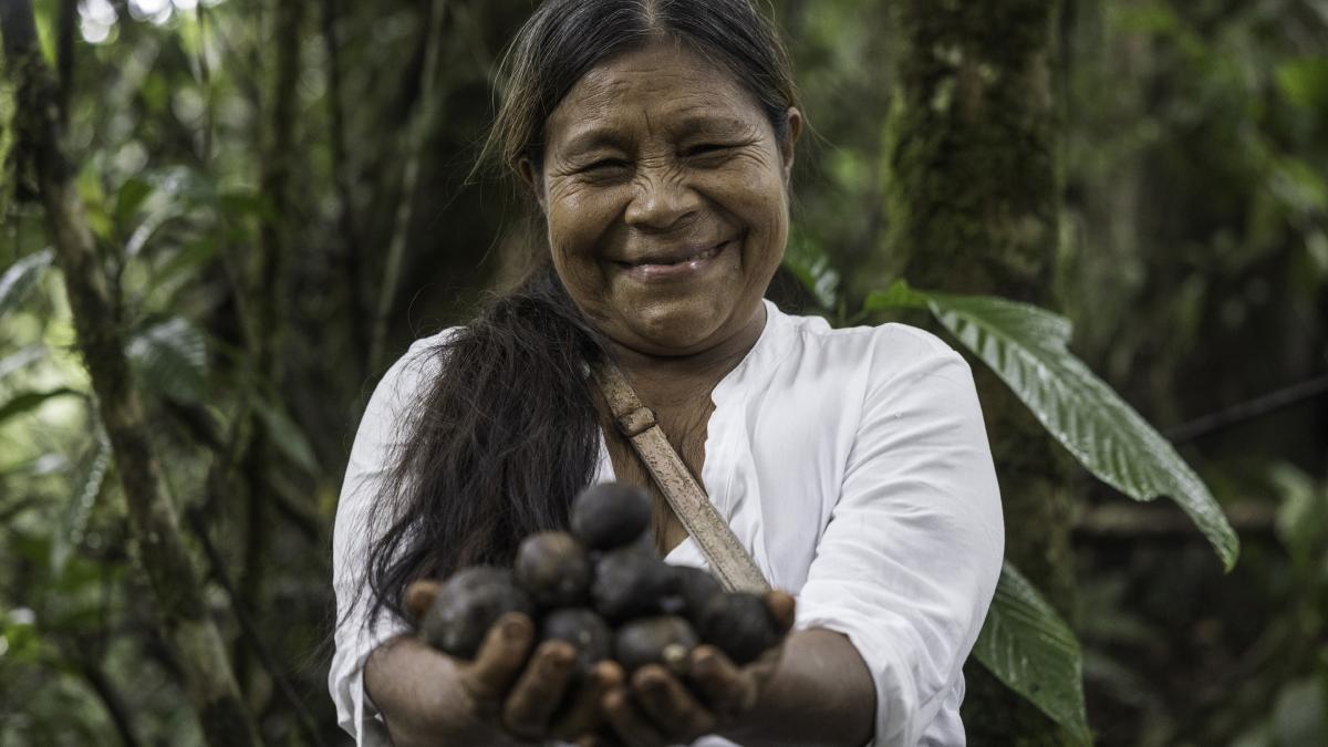 Indigenous woman smiles while holding inchi