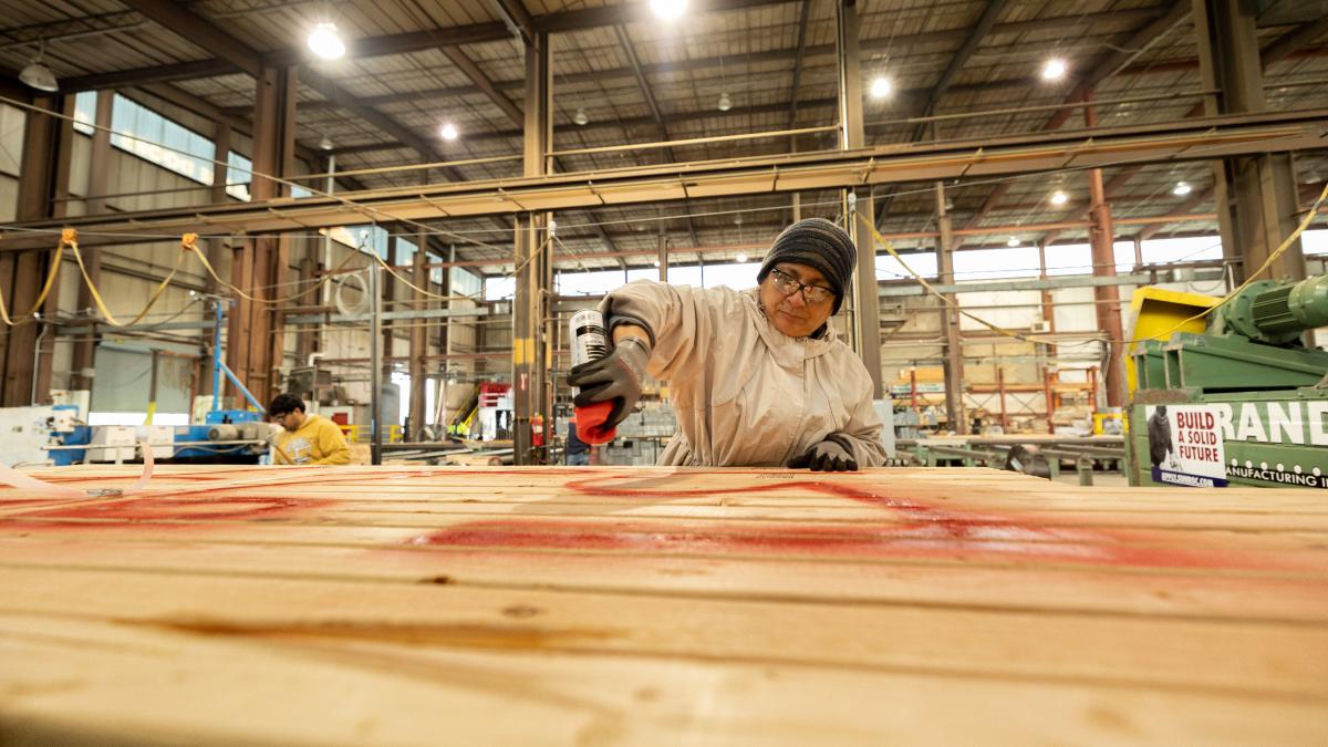  A Salvadoran migrant participating in the H-2 temporary visa program works at a construction firm in Utah marking newly made trusses for a building.