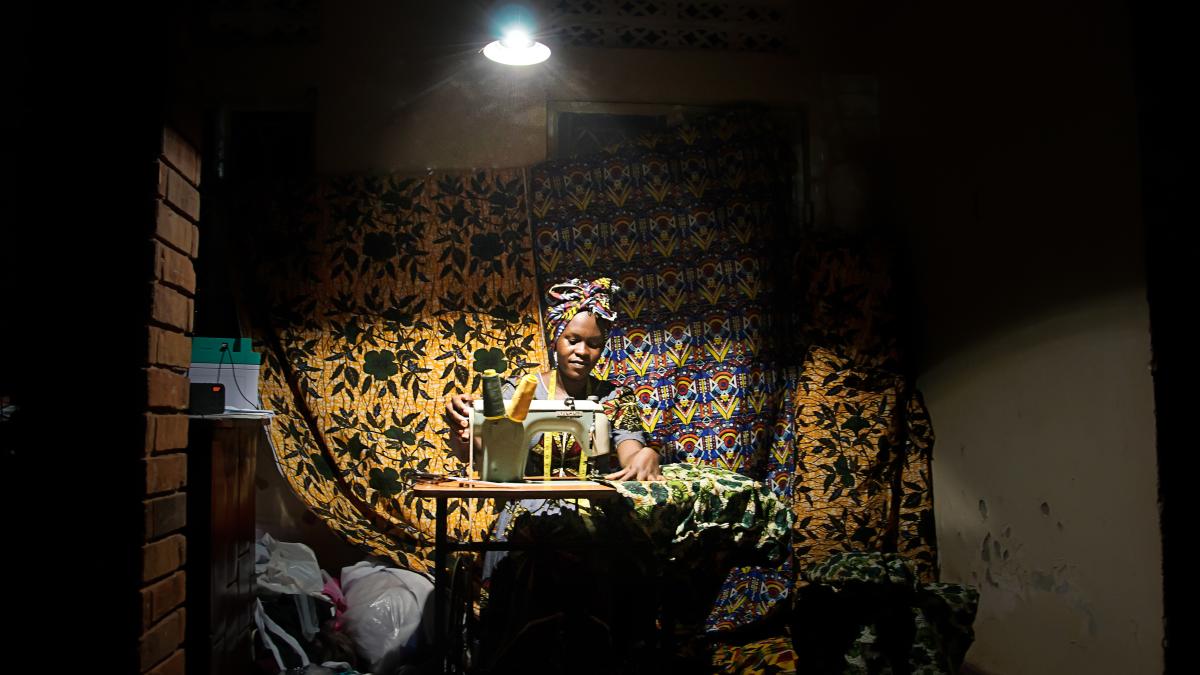 An African seamstress working under a bring light