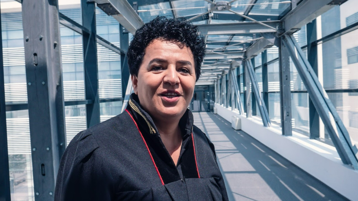 A judge in Kosovo poses along a glass-sided walkway