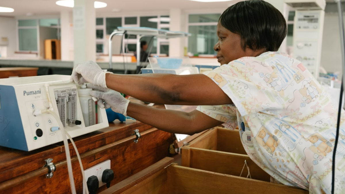 A nurse attends to medical equipment in a hospital.