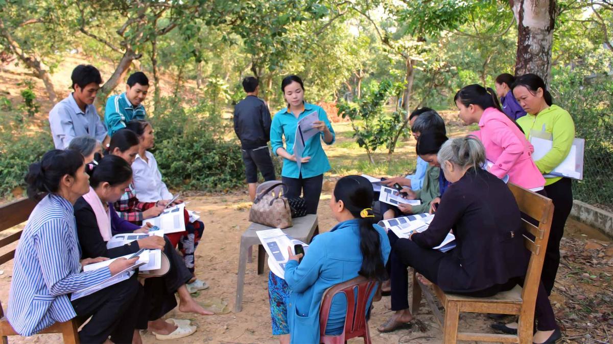 Community members meet in a park for a presentation