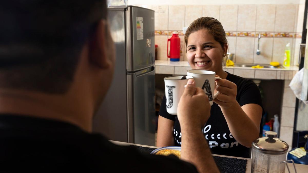 Adriana and Jose drinking coffee during a moment of rest in their kitchen.