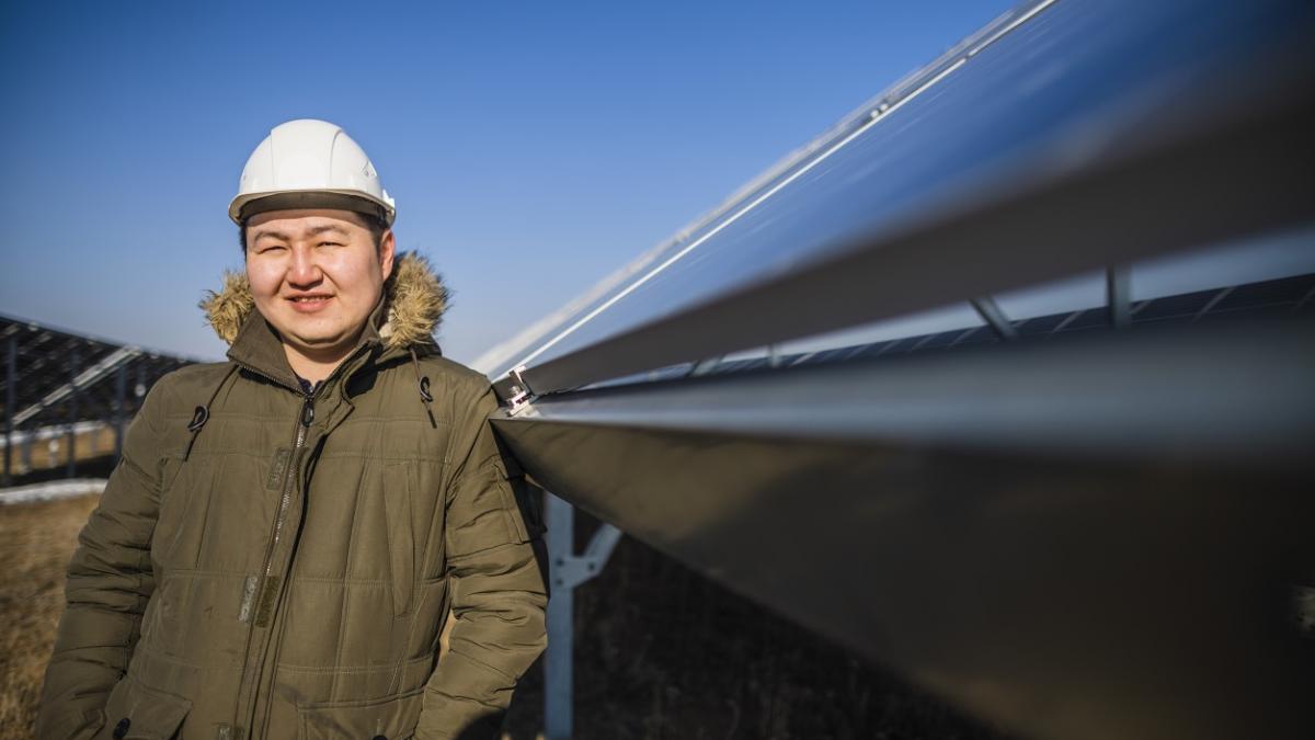 A man in a hard hat stands in front of a large conduit