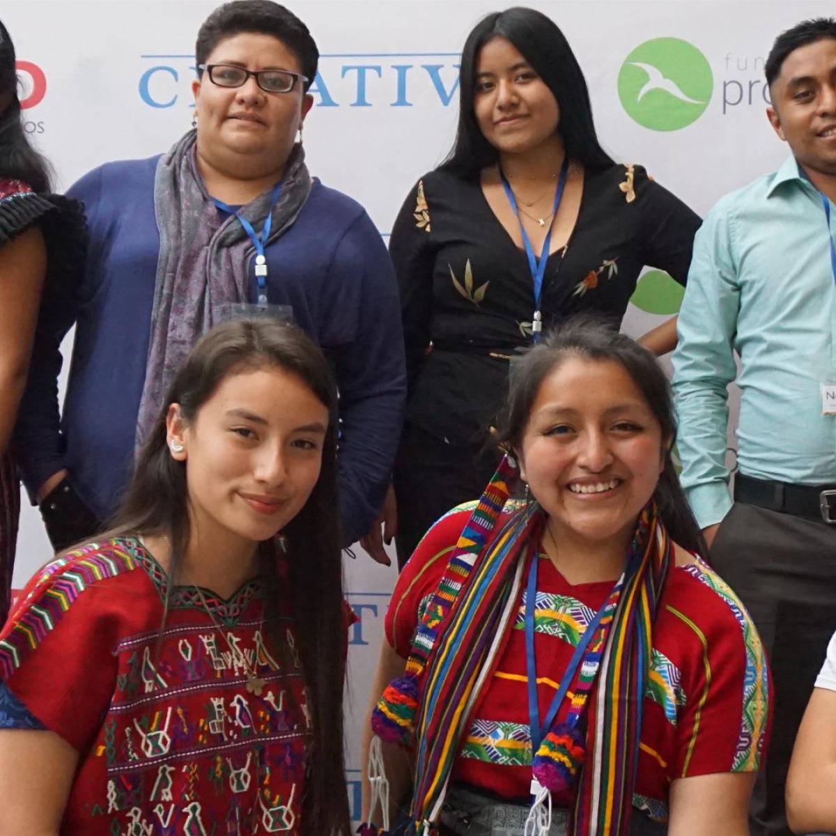 Smiling group of people in front of a banner in Guatemala