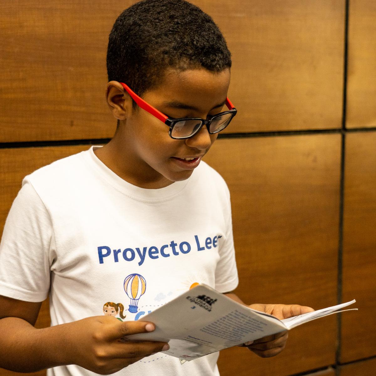 Child reads and focuses on USAID READ Project's book.