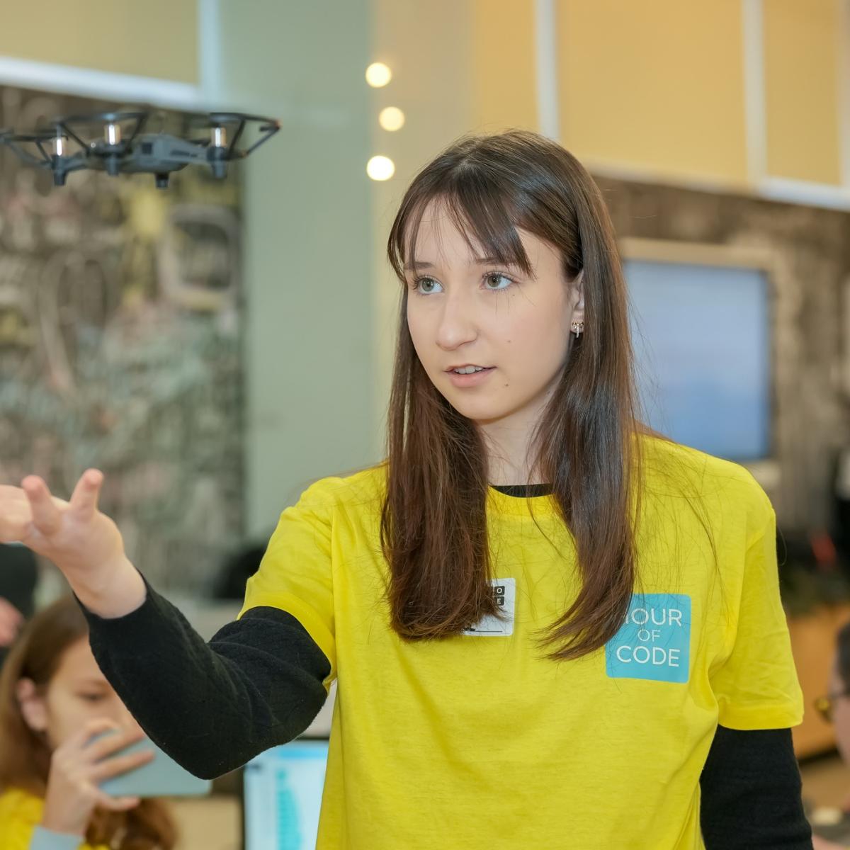 A girl with a drone hovering over her hand