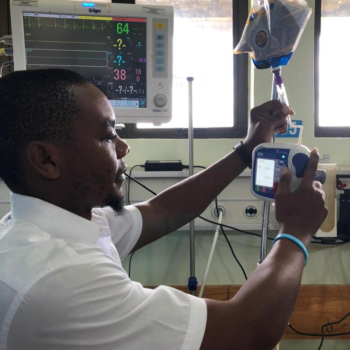 Registered dietitian Jonathan Misolo installs a feeding pump in an intensive care unit in Lilongwe.