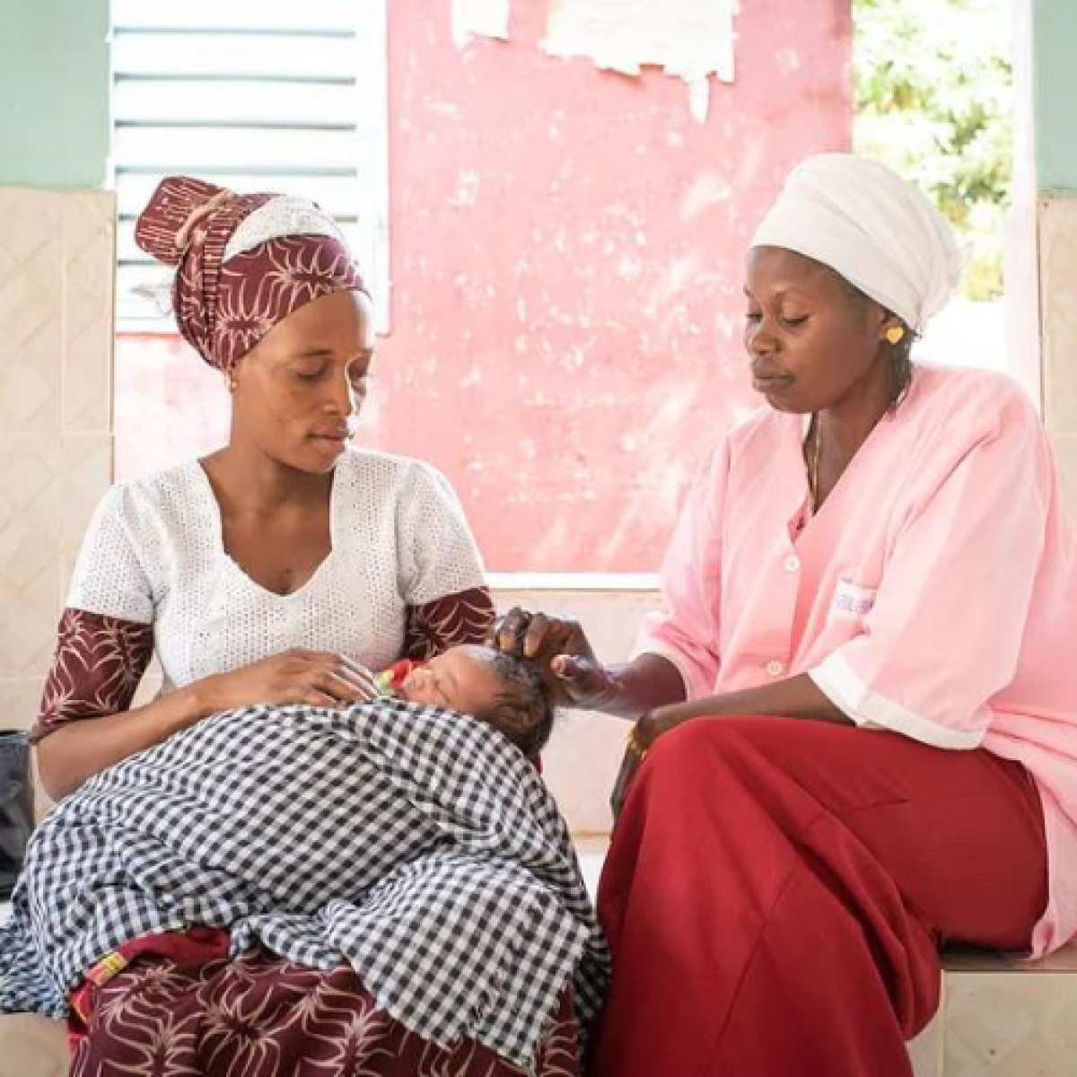 Djiba Balde sits with her child, Aissatou Balde, and the matron Penda Balde, after a consultation in the health center of Sarre Bilaly in the Kolda region, Senegal.