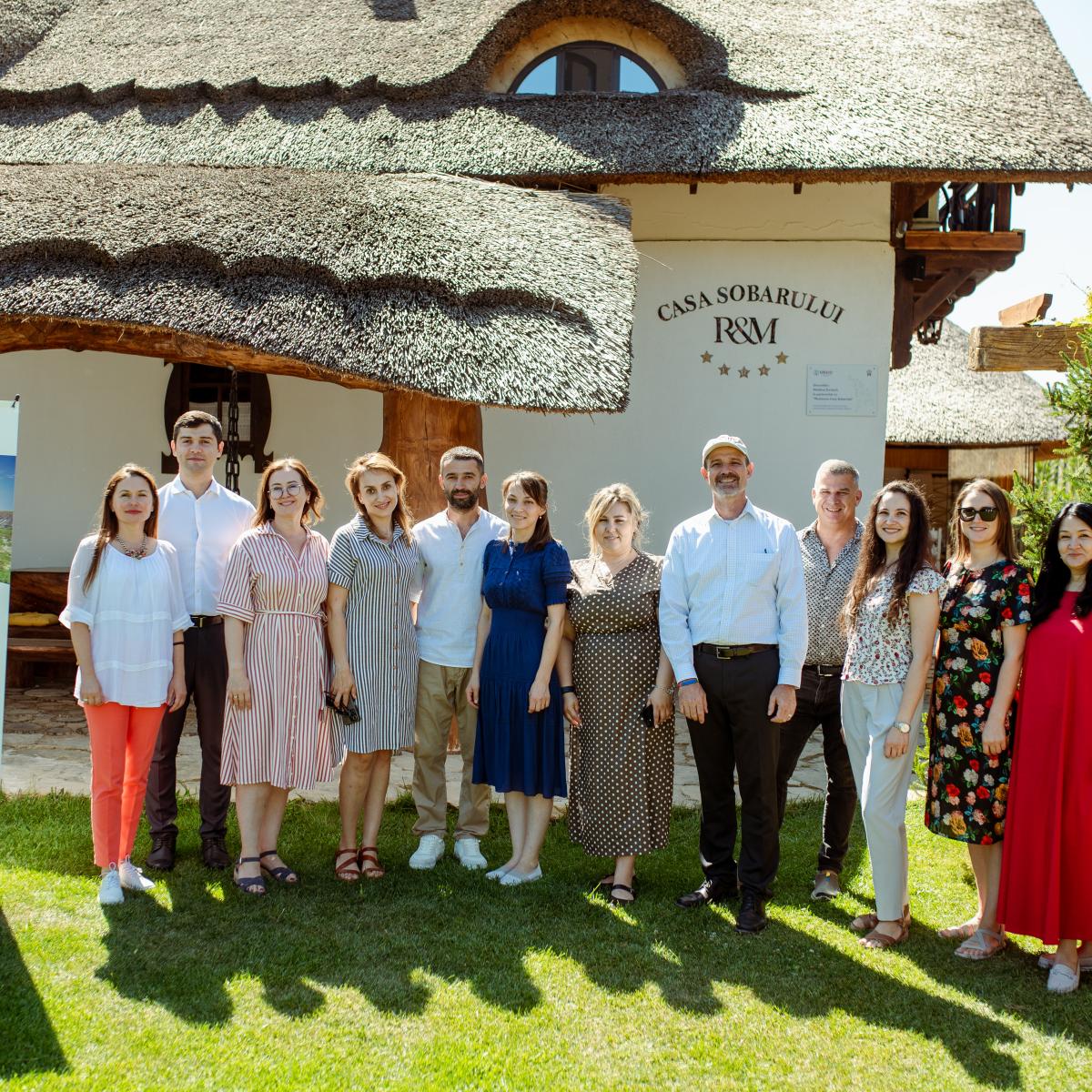 A group of people in front of a guesthouse supported by USAID Moldova's RCRA 