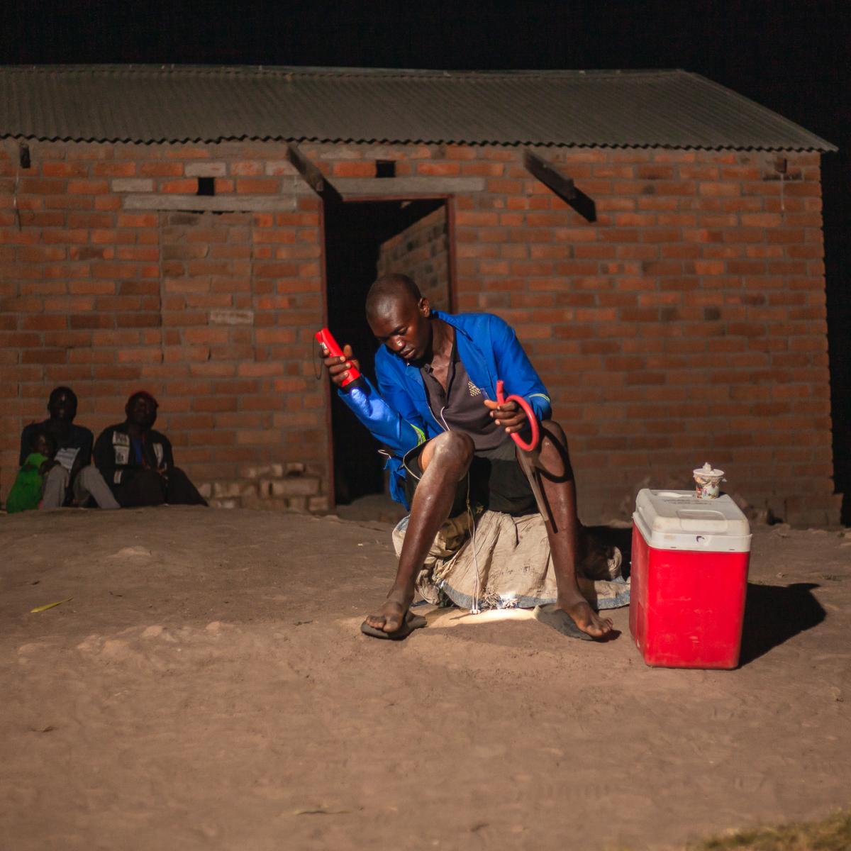 Micheal Banda, a human landing collector, exposes his skin to mosquitoes to trap them as they attempt to bite. 