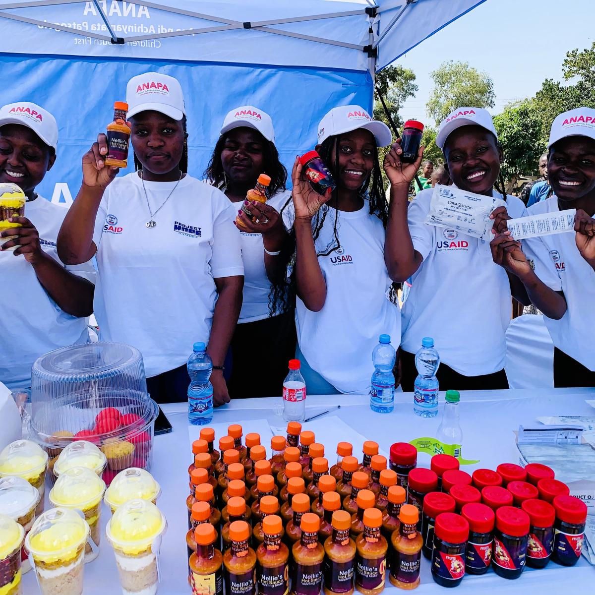 Youthful beneficiaries display their merchandise made using skills from the program, which also aims to empower the youth and adolescents to be economically independent as a way of deterring them from risky behaviour. Photo Credit: Oris Chimenya/USAID