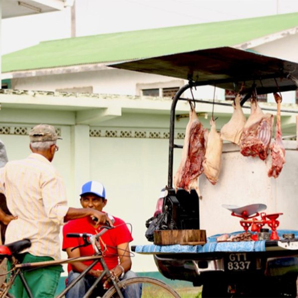 Wild meat for sale is displayed hanging from a truck.