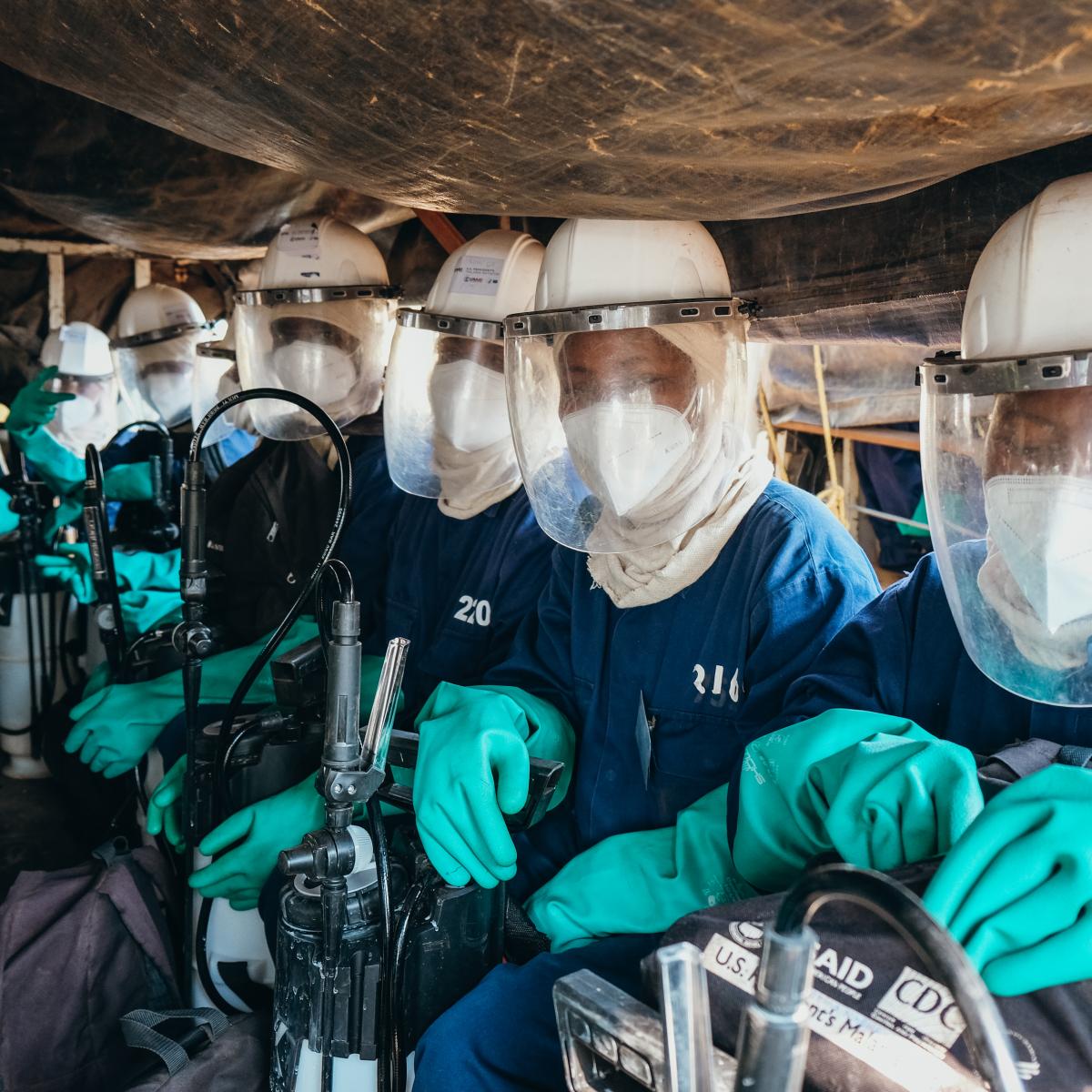 A group of indoor residual sprayers sit in a truck on their way to a spray site