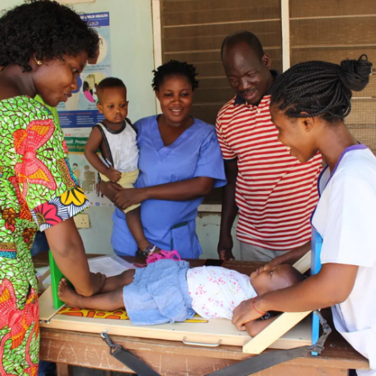 A supervisor coaching health workers at the Loagri Health Centre in Ghana on height measurement for young children.