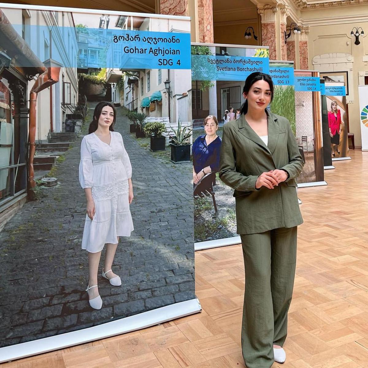 a woman stands in front of a printed display