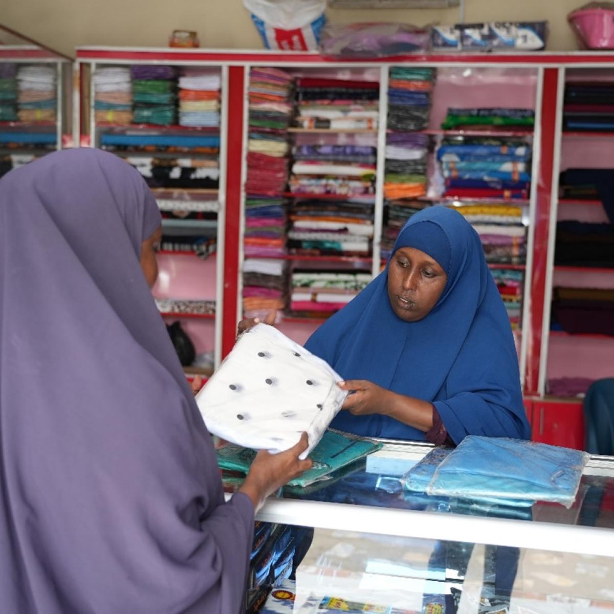 Ubah with a customer in her shop. USAID supported IBS Bank to develop micro-credit facilities and products for the marginalized groups in Somalia