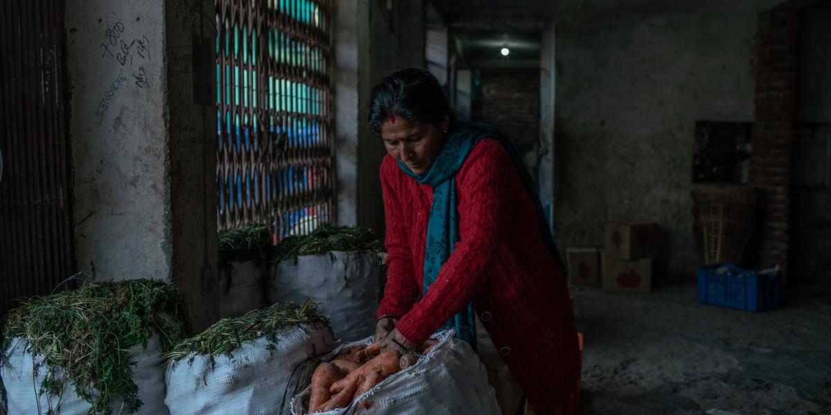 Woman examining sack of vegetables.