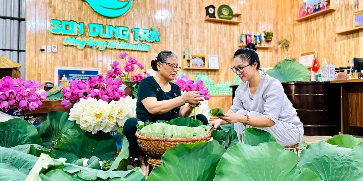 Mr. Dung and Ms. Trang senting tea with lotus flower