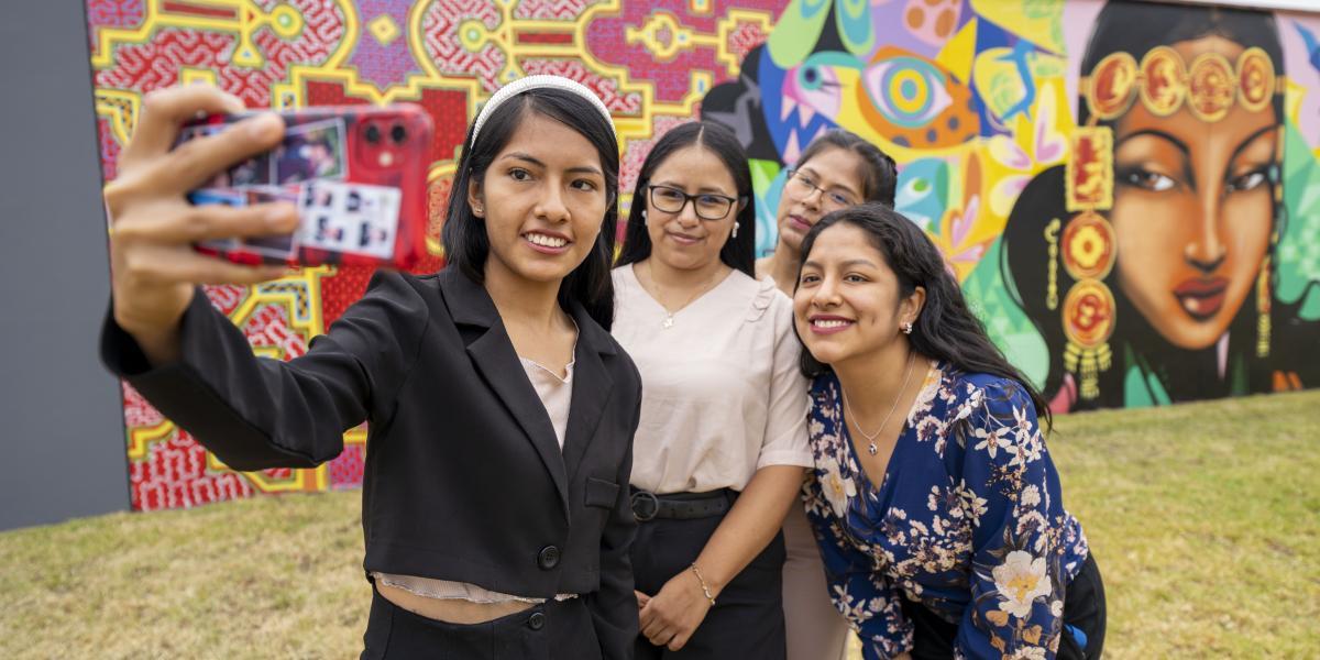 Four young women smiling and taking a selfie