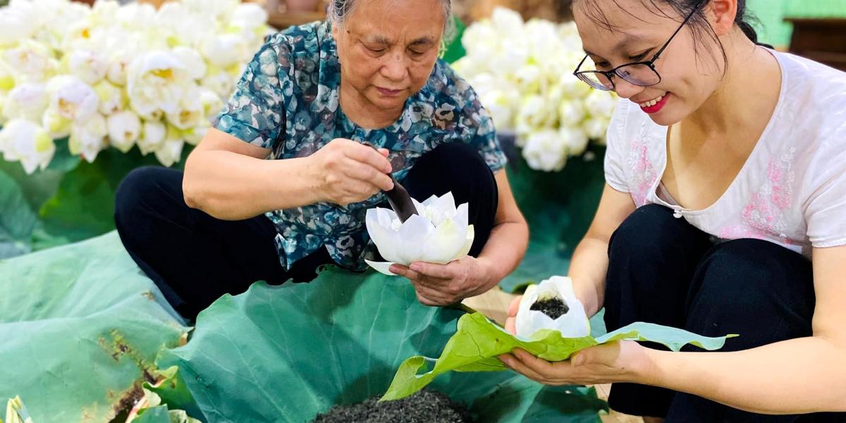 Mr. Dung and Ms. Trang senting tea with lotus flower