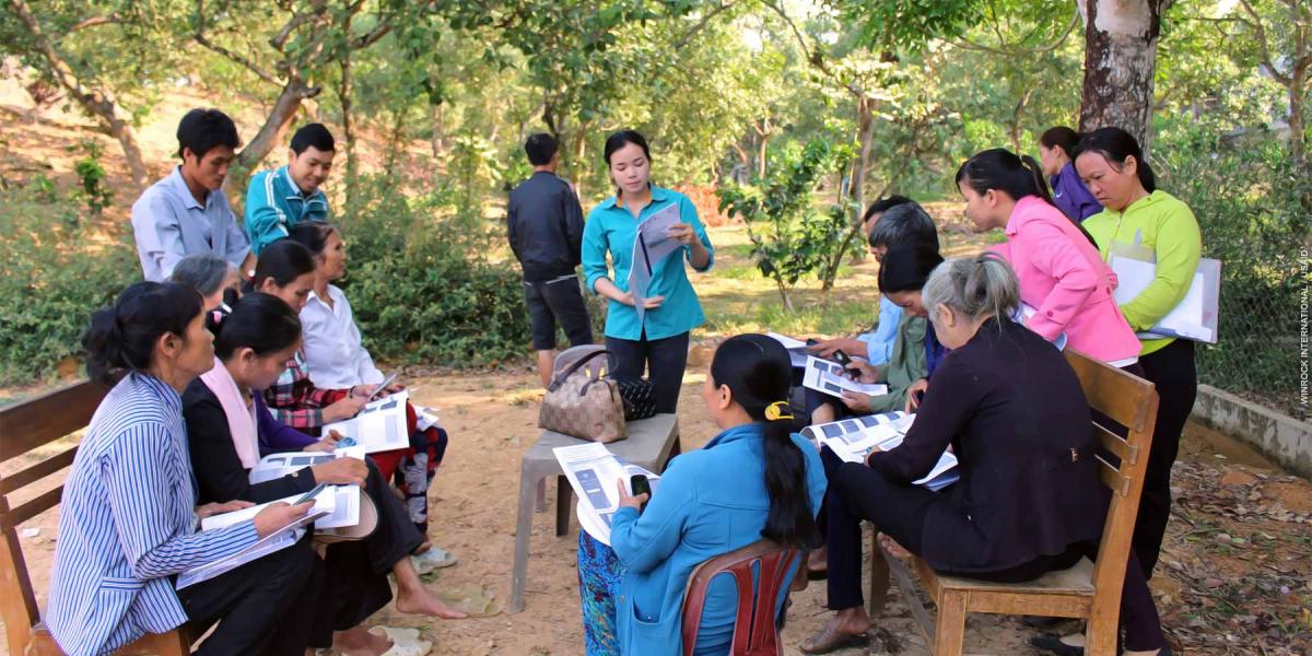 Community members meet in a park for a presentation