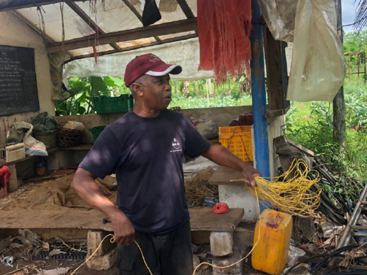 Mr. Sharji Shaaban Ameir in front of his Farm Shed where he keeps records of product cycles and performs training.