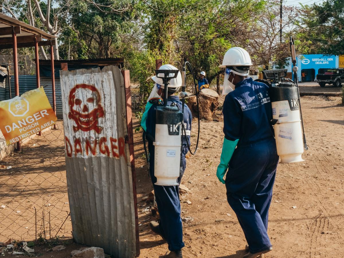 Theresa and other spray operators return their kit to spray base.