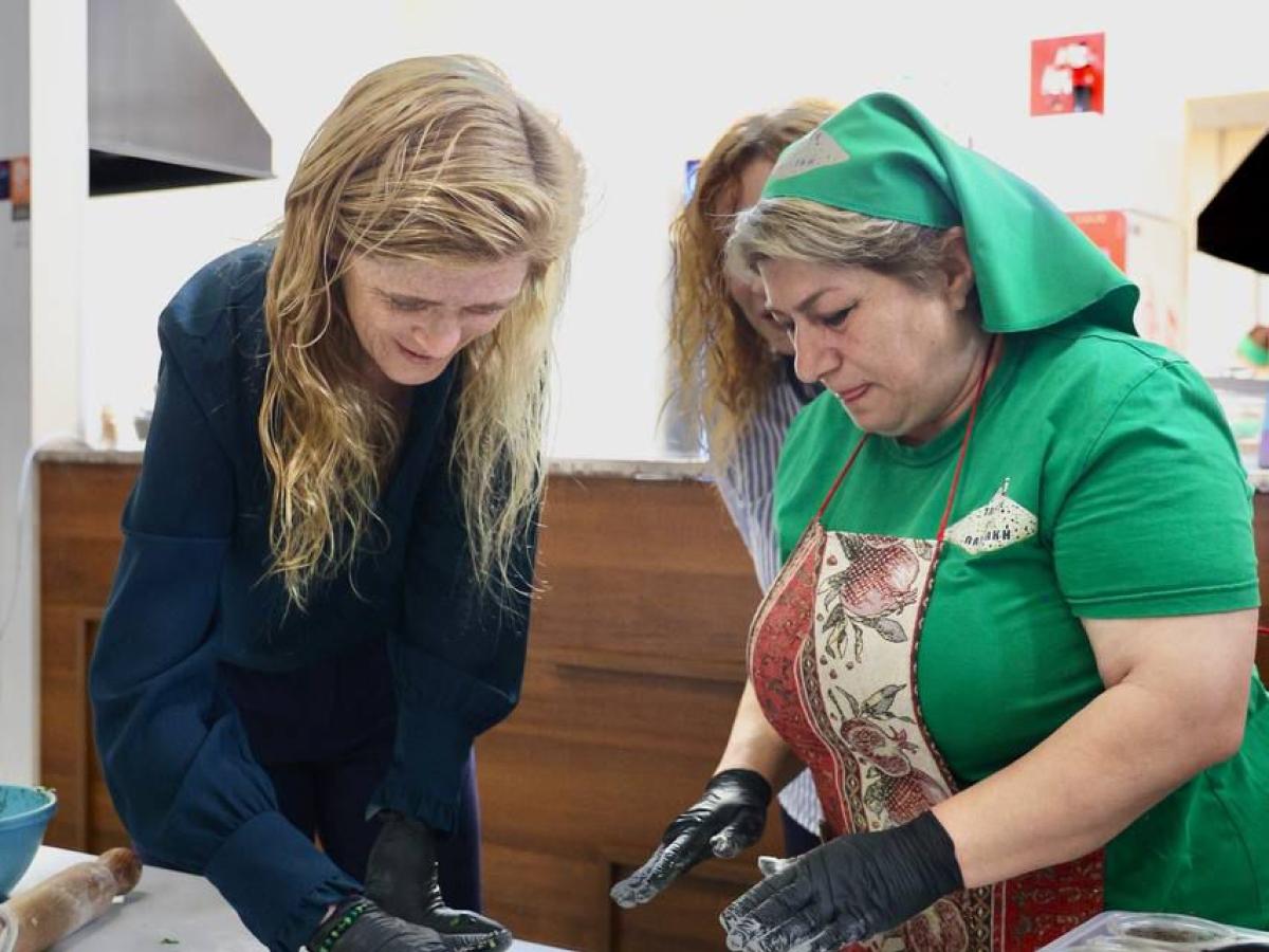 two women make a flat dough on a countertop