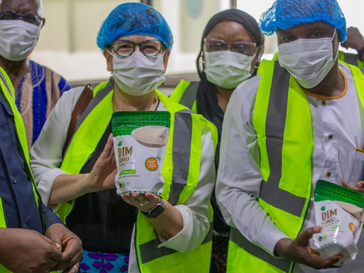 USAID Ghana Deputy Mission Director shows off a new package of fonio - a sustainable grain grown in Northern Ghana and processed at AMAATI's factor in Tamale, Northern Region, Ghana (May 29, 2024)