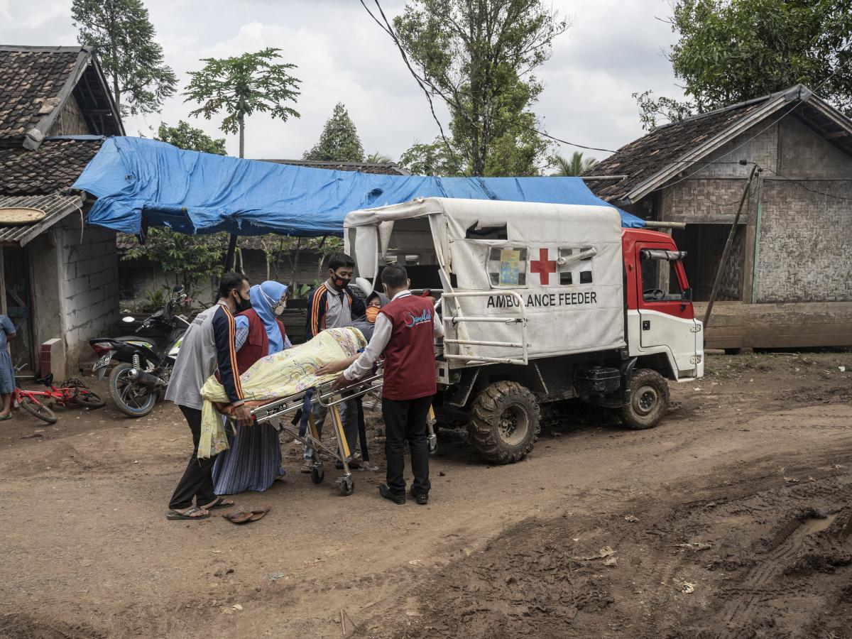 Kader membantu ibu hamil masuk ambulans pengumpan.