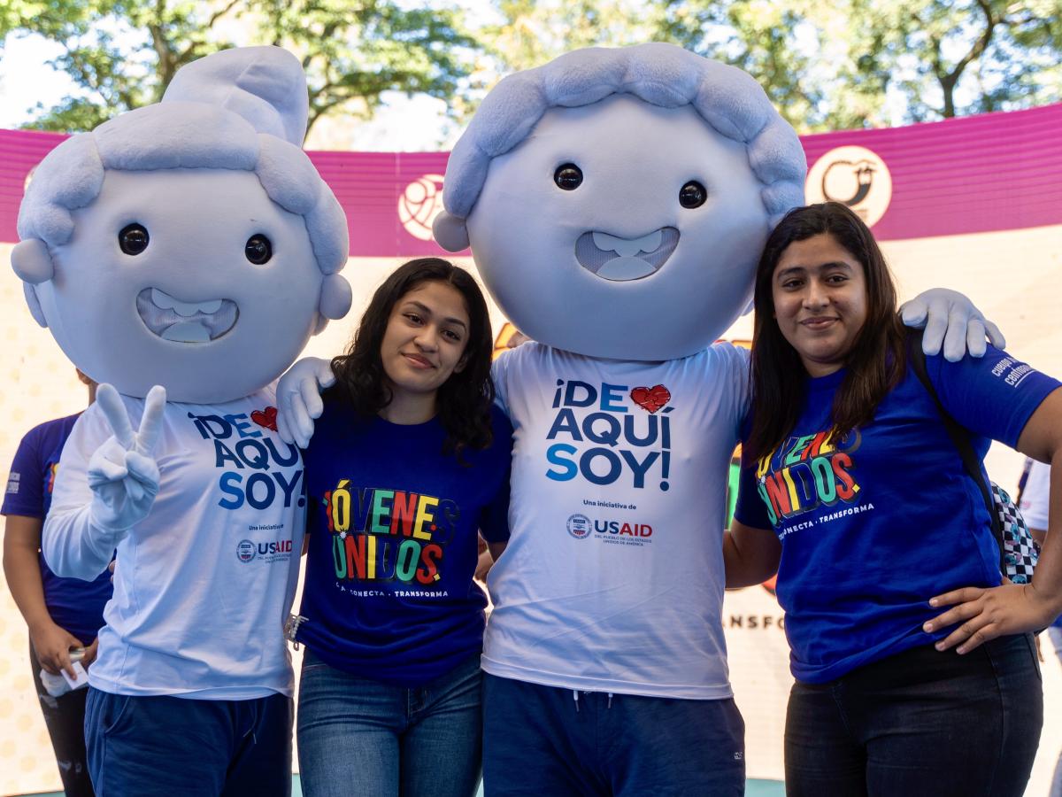  Two young Salvadoran women pose with USAID’s De Aqui Soy mascots at the Jóvenes Unidos project launch in San Salvador, El Salvador.