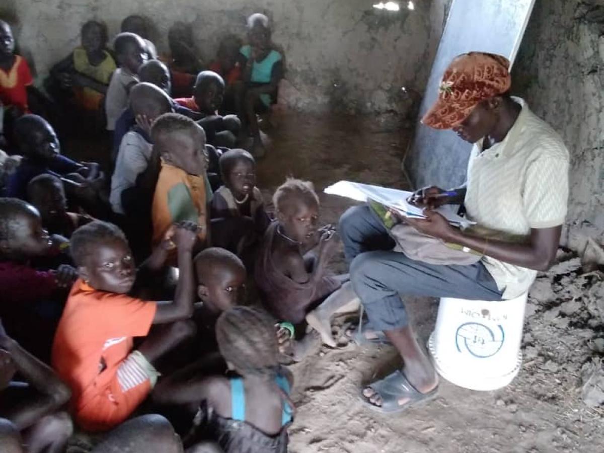 Third-grade students at Nyangore Primary School crowd into a small classroom, many seated on the ground.