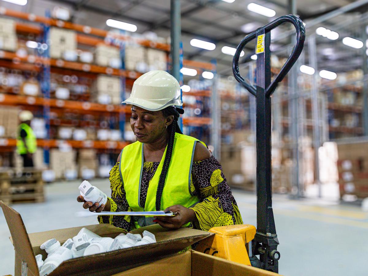 A supply chain worker takes inventory of life-saving HIV medication at a facility in Malawi. / Credit: Miléquêm Diarassouba for USAID