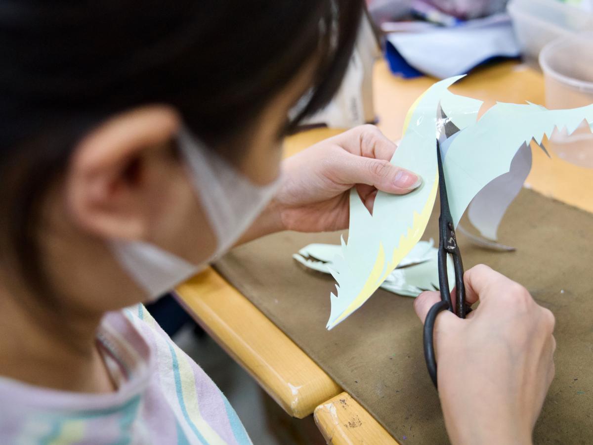 Vun Art artist cutting silk scraps into pieces for a collage.