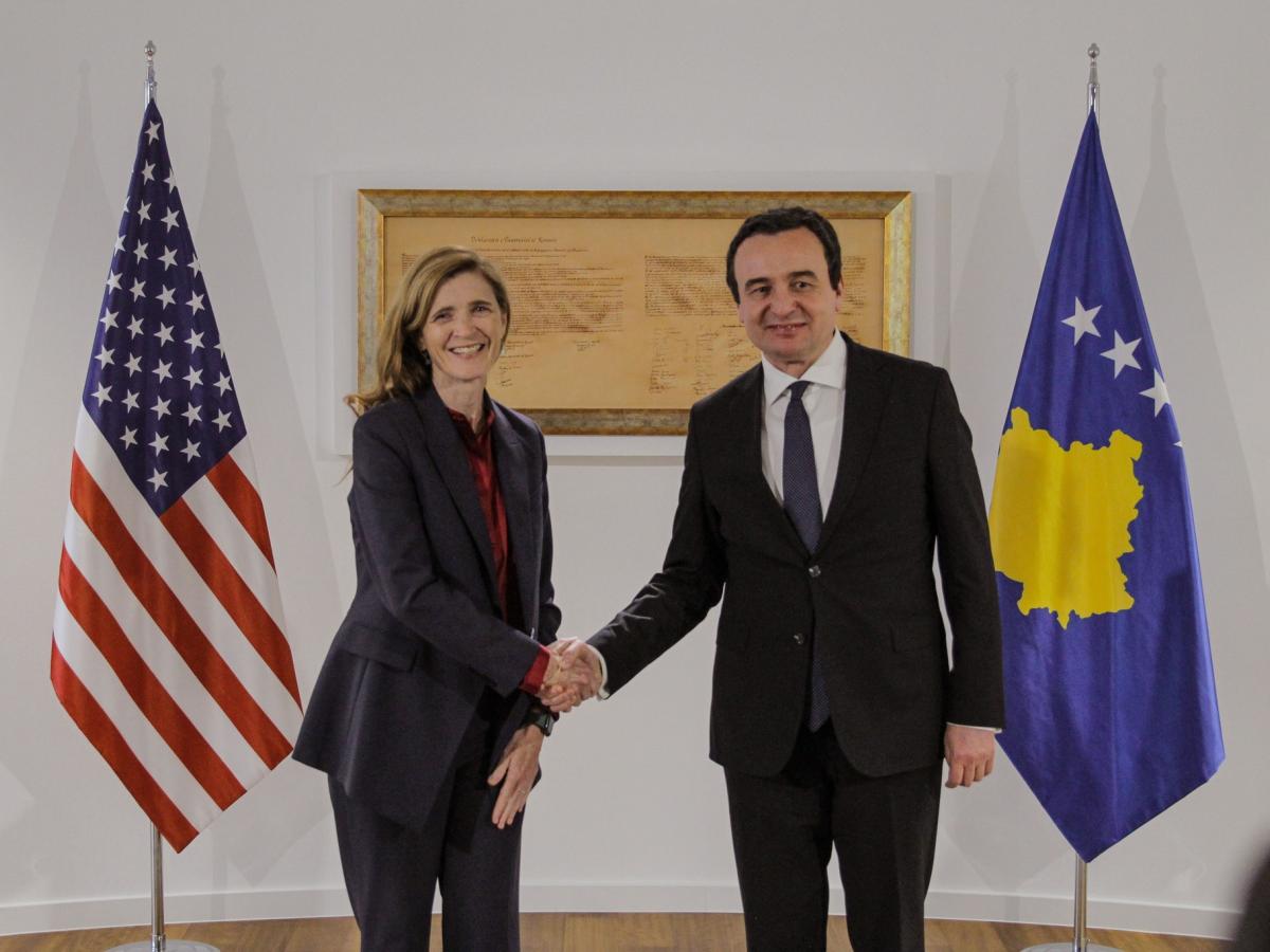 Administrator Power and Prime Minister Kurti shake hands in front of the flags of the U.S. and Kosovo