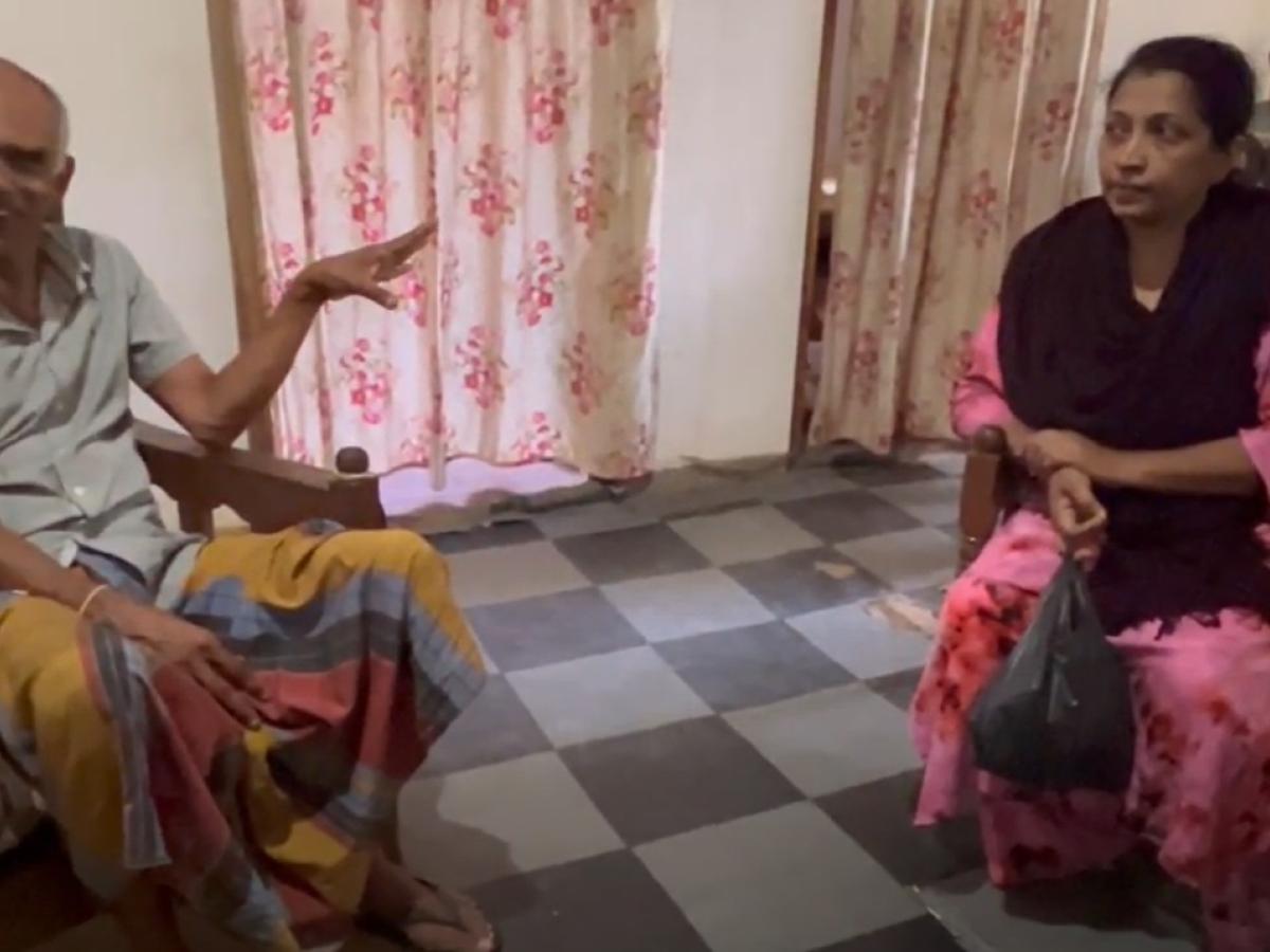 A man and a woman sit in chairs having a discussion.