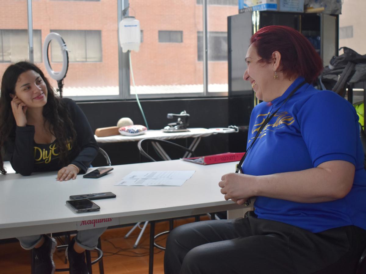 This picture shows Laura and Dani looking at each other in admiration, while they shared with the interviewer what they have learned from each other. They are smiling.