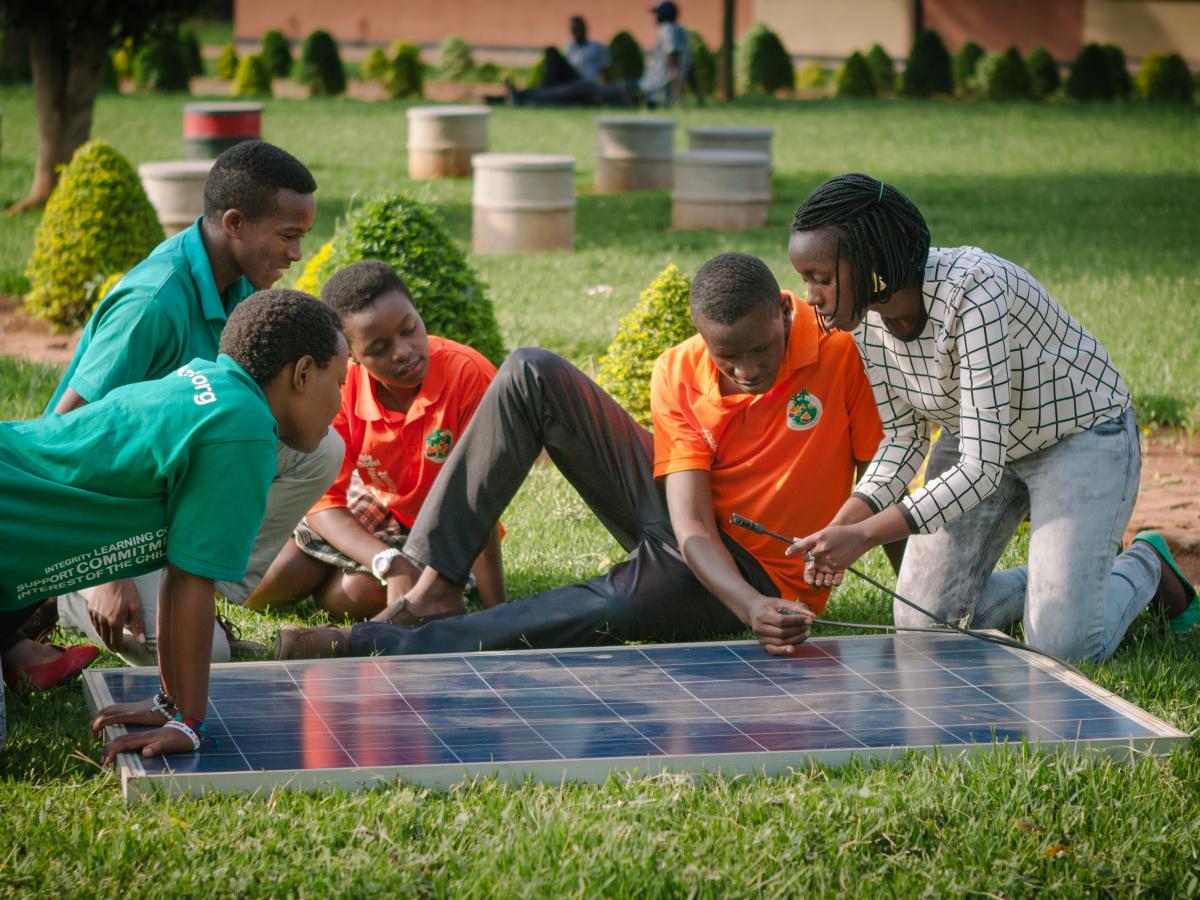 Students sitting around a solar panel