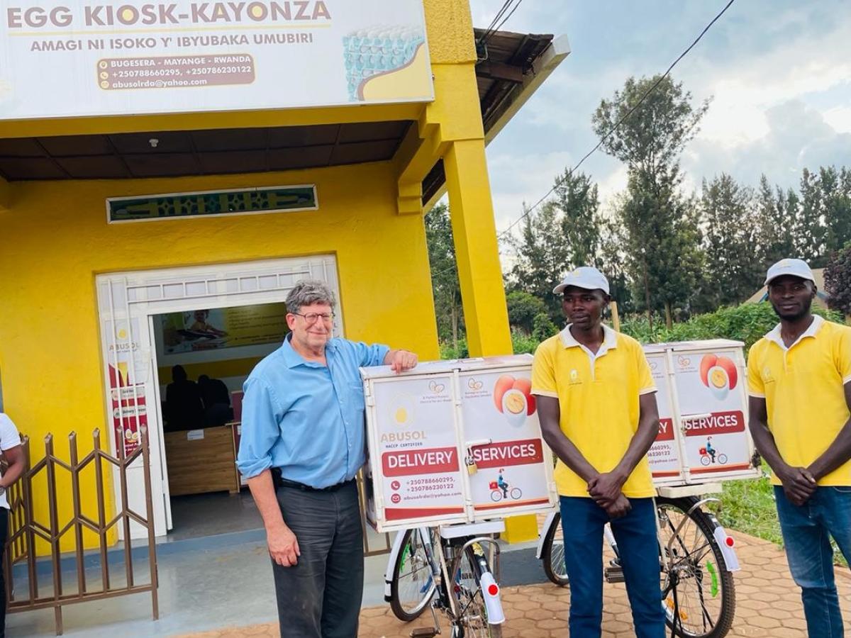 USAID Mission Director poses with two egg distributors 