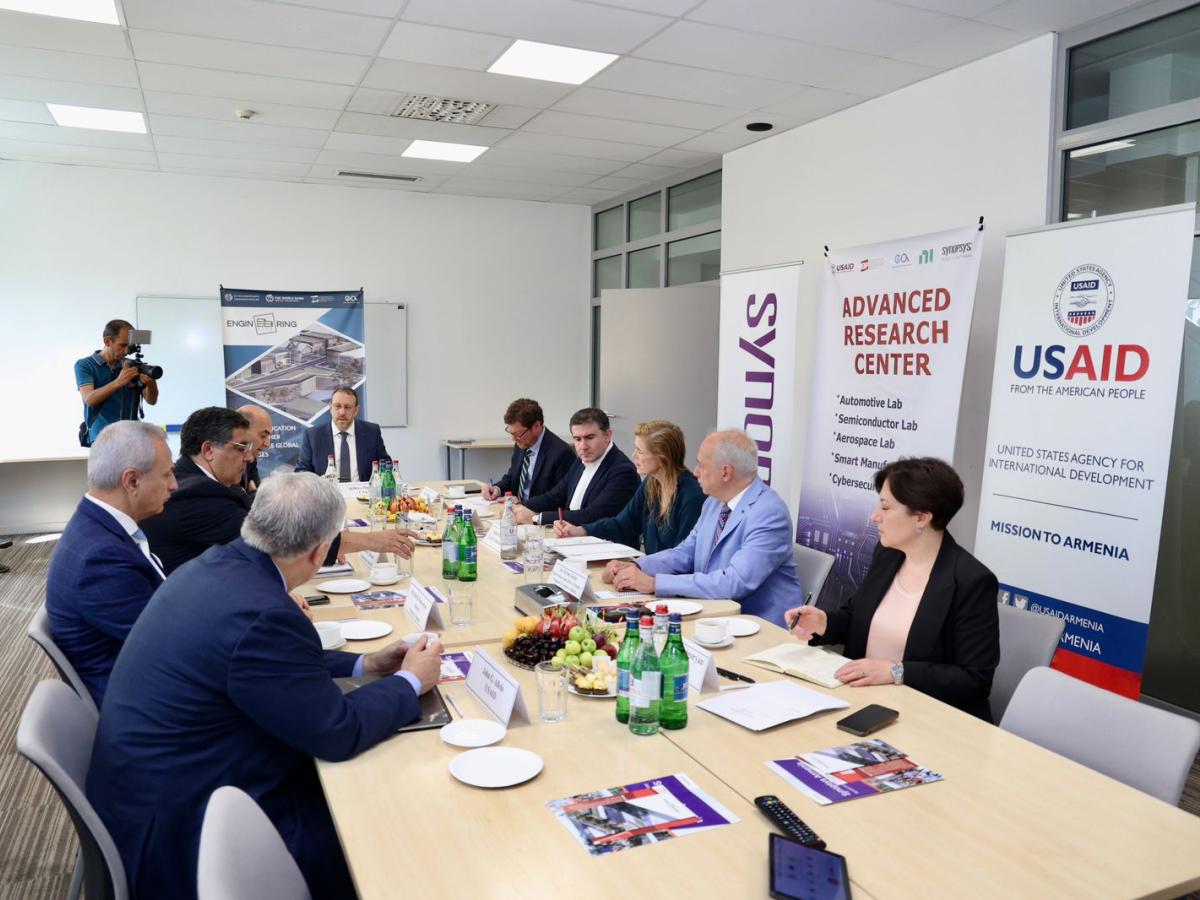 a group of people sitting at a long meeting table