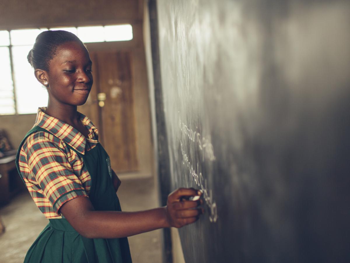 A student writes on a chalkboard