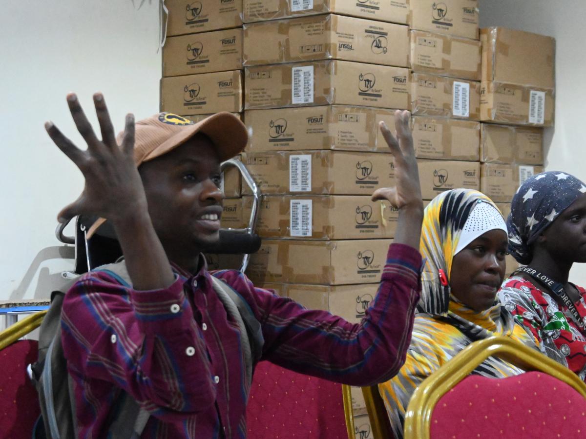 Deaf participant in an electoral workshop enthusiastically signs “transparency.”