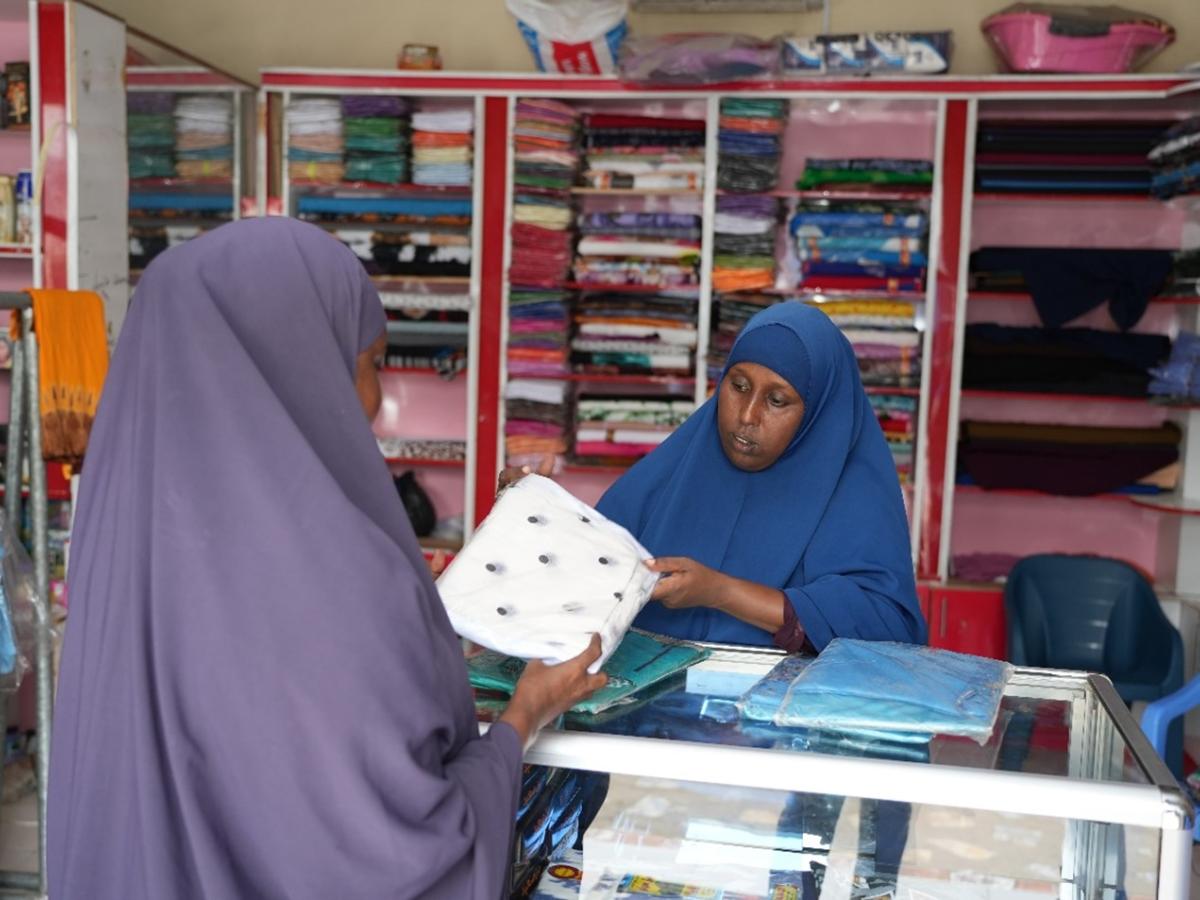 Ubah with a customer in her shop. USAID supported IBS Bank to develop micro-credit facilities and products for the marginalized groups in Somalia