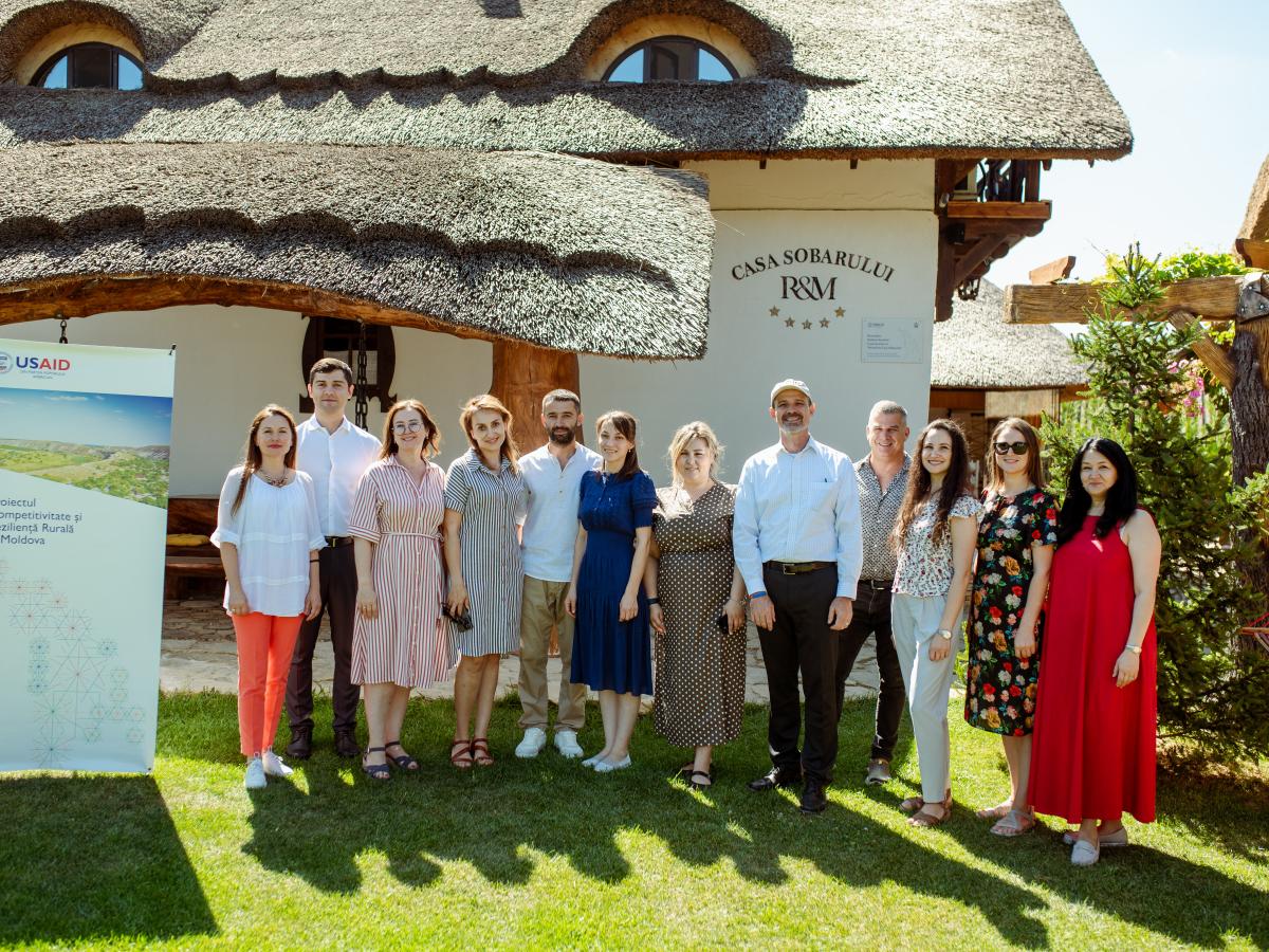 A group of people in front of a rural guesthouse supported by USAID Moldova's RCRA.