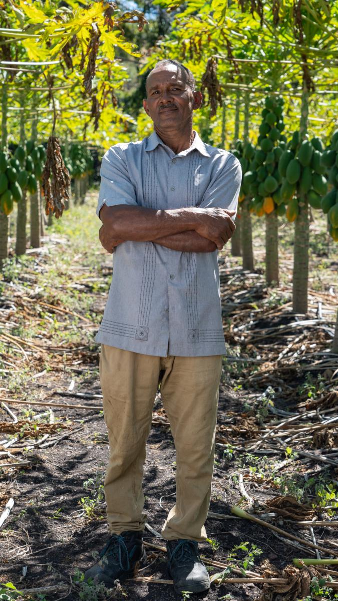 Miguel poses for a picture. His papaya trees are behind him.