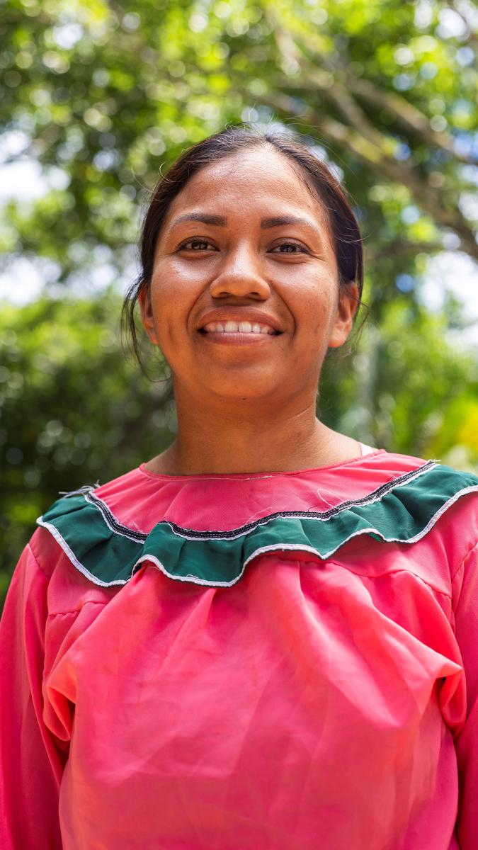 An indigenous woman smiling in the Amazon rainforest