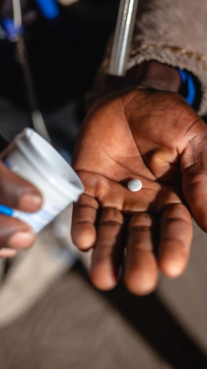 Mosquito collector (Micheal Banda) taking deltaprim (directly observed) – a prophylaxis to prevent malaria infection in case collectors are accidentally bitten by infected mosquitoes while working. / Kalichi for USAID